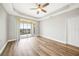 Bright bedroom with wood-look floors, ceiling fan, and private balcony access at 255 West End Dr # 1412, Punta Gorda, FL 33950