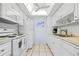 Bright kitchen featuring white cabinetry, tile flooring, and modern appliances at 6300 Midnight Pass Rd # 20, Sarasota, FL 34242