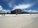 Beachfront view of condo building and beachgoers at 6300 Midnight Pass Rd # 20, Sarasota, FL 34242