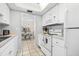 Kitchen boasts white cabinets, gas range, and view to dining area at 6300 Midnight Pass Rd # 20, Sarasota, FL 34242