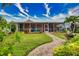 Spacious backyard with screened patio, lush landscaping, and brick pathway at 234 Fields Se Ter, Port Charlotte, FL 33952