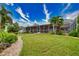 Landscaped backyard features a screened enclosure and grassy area at 234 Fields Se Ter, Port Charlotte, FL 33952