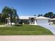 Single-story home with a white exterior, grey accents, and palm trees at 431 San Felix St, Punta Gorda, FL 33983
