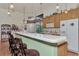 Kitchen with light green island and breakfast bar, wood cabinets, and stainless steel appliances at 8430 Acorn Blvd, Punta Gorda, FL 33982