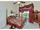 Main bedroom with a four-poster bed and access to backyard at 8430 Acorn Blvd, Punta Gorda, FL 33982