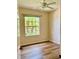 Bedroom with wood-look floors, ceiling fan and large window at 26453 Barranquilla Ave, Punta Gorda, FL 33983