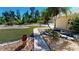 Landscaped front yard with walkway, pond, and mature tropical plants at 27200 San Marino Dr, Punta Gorda, FL 33983