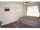 Bedroom with gray bedding, ceiling fan, and large window at 26332 Barranquilla Ave, Punta Gorda, FL 33983