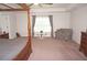 Main bedroom with large four poster bed, sitting chair, and window at 26332 Barranquilla Ave, Punta Gorda, FL 33983