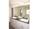 Double vanity bathroom with dark countertop and light cabinets at 26332 Barranquilla Ave, Punta Gorda, FL 33983