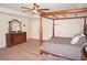 Main bedroom with large four poster bed and dresser at 26332 Barranquilla Ave, Punta Gorda, FL 33983