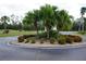 Landscaped entryway with palm trees and flowering bushes at 175 Kings Hwy # 923, Punta Gorda, FL 33983