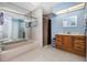 Well-lit bathroom featuring a walk-in shower, a wood vanity, and coordinated tiling at 1759 Nuremberg Boulevard, Punta Gorda, FL 33983