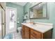 Bright bathroom with a walk-in shower, a wood vanity, and a doorway to the backyard at 1759 Nuremberg Boulevard, Punta Gorda, FL 33983