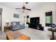 Spacious living room featuring neutral tones, a ceiling fan, and a large flat-screen television at 1759 Nuremberg Boulevard, Punta Gorda, FL 33983