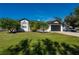 Beautiful front exterior of home with black garage door, green lawn and manicured landscaping at 23526 Chimes Ave, Port Charlotte, FL 33980