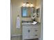Bathroom featuring a granite countertop, white cabinets, decorative mirror, and soft lighting at 22235 Albany Ave, Port Charlotte, FL 33952