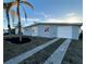 Inviting home featuring a long driveway, one car garage and tropical landscaping with palm trees at 4127 Gardner Dr, Port Charlotte, FL 33952