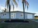 Charming single-story home with a fresh exterior, palm trees and a well-manicured lawn at 4127 Gardner Dr, Port Charlotte, FL 33952