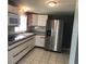 Kitchen with stainless steel refrigerator, white cabinets, and tile floor at 4127 Gardner Dr, Port Charlotte, FL 33952