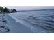 Scenic beach view with calm water and pier in the background at 4127 Gardner Dr, Port Charlotte, FL 33952