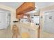 Kitchen with breakfast bar, wood cabinets, and white appliances at 26485 Rampart Blvd # D28, Punta Gorda, FL 33983