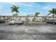 Front view of condo building with parking lot and landscaping at 26485 Rampart Blvd # D28, Punta Gorda, FL 33983