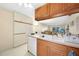 Kitchen with wood cabinets, double sink, and a view into the living area at 26485 Rampart Blvd # D28, Punta Gorda, FL 33983