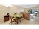 Small dining area with glass-top table and wicker chairs at 26485 Rampart Blvd # D28, Punta Gorda, FL 33983