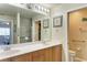 Bathroom with double sinks, a large mirror, wood cabinets, and a tiled shower at 3322 Purple Martin Dr # 135, Punta Gorda, FL 33950