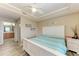 Comfortable bedroom with white furniture, ceiling fan, and a view into the bathroom at 3322 Purple Martin Dr # 135, Punta Gorda, FL 33950