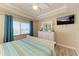 Bedroom featuring a large window with blinds, dresser, ceiling fan, and a TV at 3322 Purple Martin Dr # 135, Punta Gorda, FL 33950
