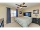 Cozy bedroom with a ceiling fan, a window with blue curtains, and neutral wall art at 3322 Purple Martin Dr # 135, Punta Gorda, FL 33950