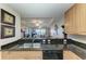 Kitchen view to living room with bar seating, stone counters, and open floorplan at 3322 Purple Martin Dr # 135, Punta Gorda, FL 33950