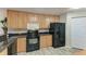 Well-equipped kitchen features wooden cabinets, black appliances and granite countertops at 3322 Purple Martin Dr # 135, Punta Gorda, FL 33950
