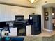 Modern kitchen with white cabinets, black appliances, and granite countertops at 98 Vivante Blvd # 98412, Punta Gorda, FL 33950