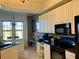 Eat-in kitchen with white cabinets, granite countertops and a built-in desk area at 98 Vivante Blvd # 98412, Punta Gorda, FL 33950