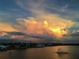 Stunning sunset over calm water with houses and fountain visible at 98 Vivante Blvd # 98412, Punta Gorda, FL 33950