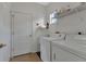 Functional laundry room with a washing machine, dryer, and convenient shelving for storage at 1712 Lastingham Ln, Port Charlotte, FL 33980