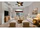Bright living room boasts a ceiling fan, an area rug, furniture and decor, and a view to the exterior at 1712 Lastingham Ln, Port Charlotte, FL 33980