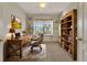 Well-lit home office with built-in shelving, a large desk, and a comfortable chair at 1712 Lastingham Ln, Port Charlotte, FL 33980
