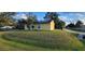 Cute yellow house with solar panels and a well-maintained lawn at 21427 Michigan Ave, Port Charlotte, FL 33952