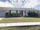 White house with red door, two-car garage, and landscaping at 21277 Edgewater Dr, Port Charlotte, FL 33952