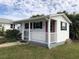 White guest house with covered porch and striped chairs at 21277 Edgewater Dr, Port Charlotte, FL 33952