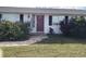 Front view of a white house with red door and landscaping at 21277 Edgewater Dr, Port Charlotte, FL 33952