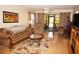 Living room with comfy furniture, wood floors, and access to a screened patio at 175 Kings Hwy # 411, Punta Gorda, FL 33983