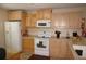 Bright kitchen with light wood cabinets, white appliances, and ample counter space at 175 Kings Hwy # 411, Punta Gorda, FL 33983