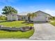 Single-story home with metal roof, landscaped yard, and attached garage at 18882 Ayrshire Cir, Port Charlotte, FL 33948