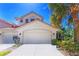 Exterior of charming two-story home with a two-car garage and lush landscaping at 4648 Club Dr # 102, Port Charlotte, FL 33953