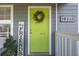 Inviting front door with lime green paint, wreath, and house numbers at 16115 Aralia Dr, Punta Gorda, FL 33955